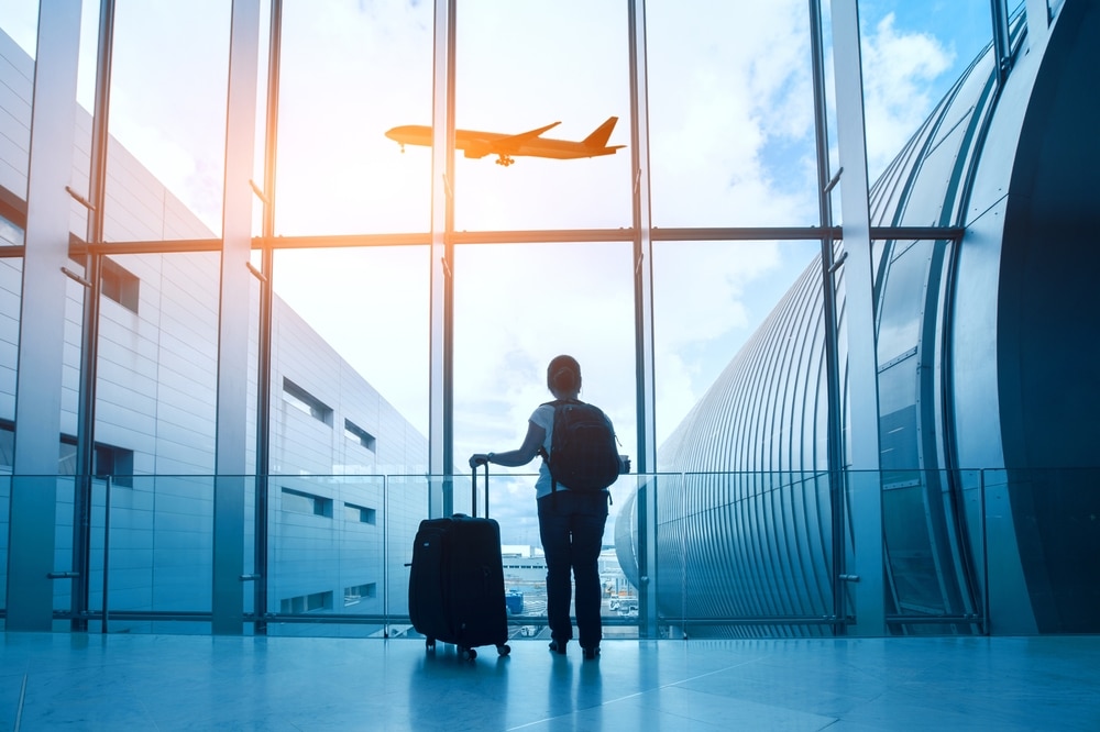 TravelConceptWomanInAirportPassengerSilhouetteWaitingWithLuggage